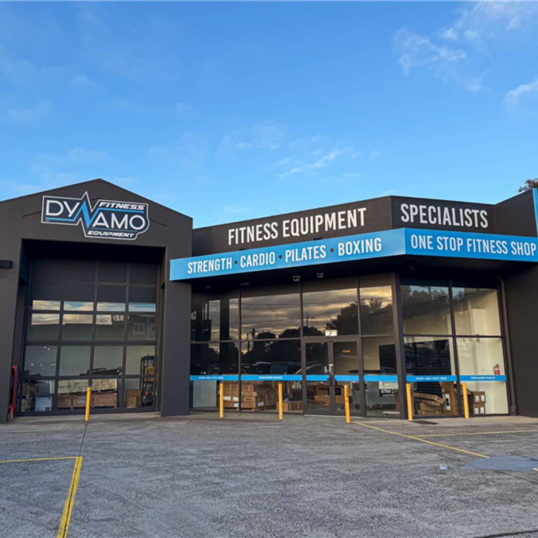 Fitness equipment store with 'Dynamo Fitness Equipment' branding on a clear day.
